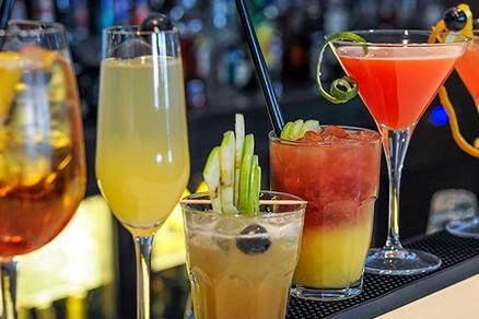 An assortment of colorful and refreshing drinks arranged on a table during a dhow cruise and the drinks range from fruity cocktails